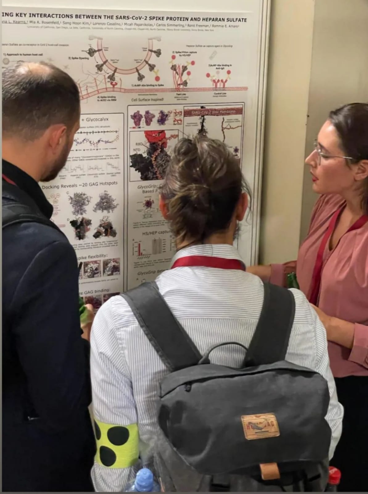 Picture of myself presenting my poster to two other conference attendees. 